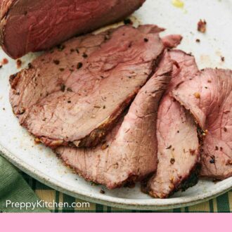 Pinterest graphic of a close up view of the multiple thinly sliced slices of roast beef on a platter.