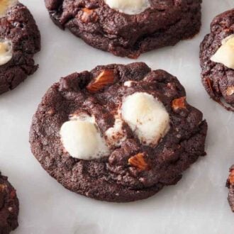 Multiple rocky road cookies on a marble surface.