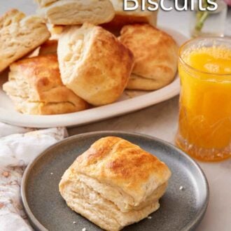 Pinterest graphic of a plate with a sourdough biscuit with an orange juice and platter of more biscuits in the back.