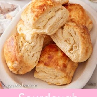 Pinterest graphic of a platter of sourdough biscuits with butter in the background.