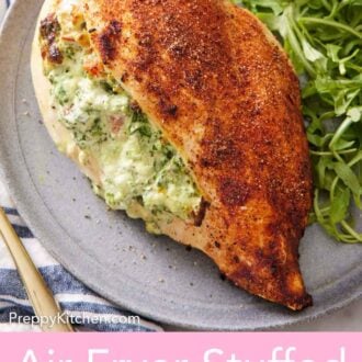 Pinterest graphic of a plate with an air fryer stuffed chicken breast along with some arugula.