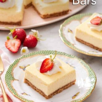 Pinterest graphic of a plate with a cheesecake bar with whipped cream and strawberry on top. More cheesecake bars in the background.