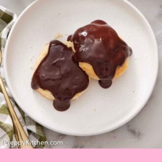 Pinterest graphic of an overhead view of a plate of chocolate gravy over two biscuits.