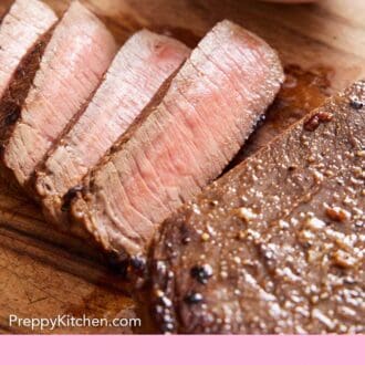 Pinterest graphic of a close up view of sliced London broil on a wooden cutting board.