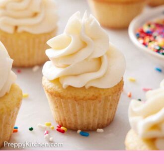 Pinterest graphic of mini cupcakes with sprinkles scattered around on the marble surface.