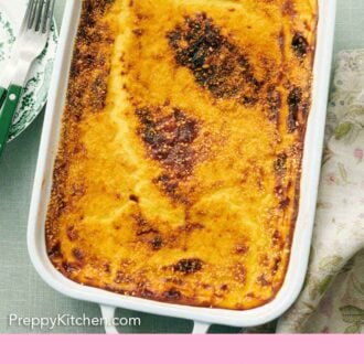 Pinterest graphic of a white baking dish with a freshly baked moussaka.