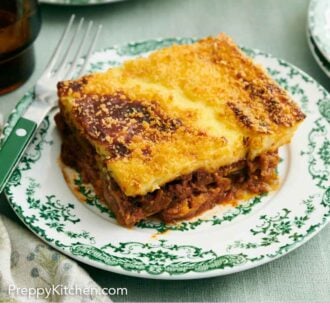 Pinterest graphic of a plate with a serving of moussaka with a fork.