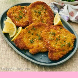 Pinterest graphic of a platter of schnitzels topped with salt and parsley surrounded by lemon wedges.