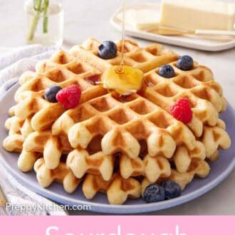 Pinterest graphic of maple syrup poured over a plate of sourdough waffles with berries.