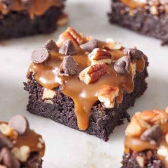 Cut pieces of turtle brownies on a marble surface.