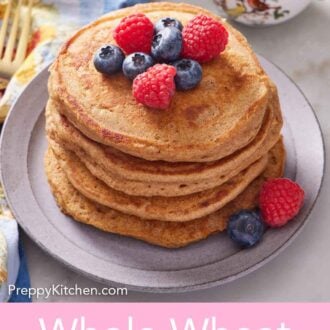 Pinterest graphic of a stack of whole wheat pancakes topped with assorted berries.