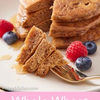 Pinterest graphic of a fork with a bite of whole wheat pancakes on a plate in front of the rest of the pancakes.