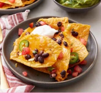 Pinterest graphic of air fryer nachos topped with sour cream on a plate. Guacamole in the background with more nachos.