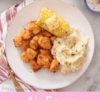 Pinterest graphic of a plate with air fryer popcorn chicken, mashed potatoes, and corn on the cob with butter on top.