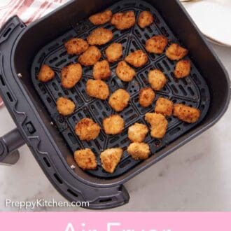 Pinterest graphic of an overhead view of air fryer popcorn chicken in an air fryer basket.