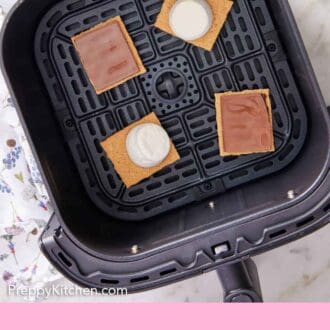 Pinterest graphic of air fryer s'mores in an air fryer basket before air frying.