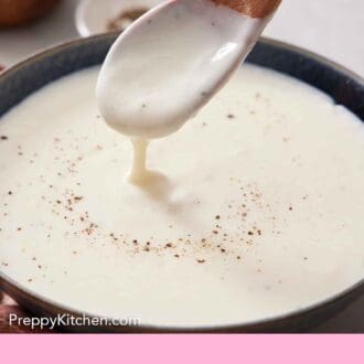 Pinterest graphic of a spoon lifting up some béchamel sauce from a bowl.