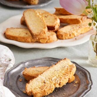 Pinterest graphic of a plate with two biscotti. A platter in the background of more biscotti along with a plate with two more.