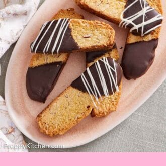 Pinterest graphic of a platter of biscotti that are half dipped in chocolate with some with a drizzle of white chocolate on top.