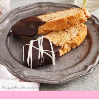 Pinterest graphic of a plate with two biscotti, half dipped in chocolate.