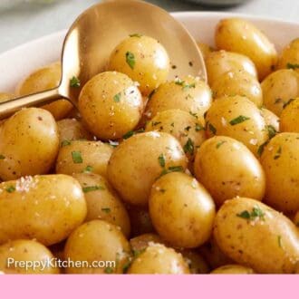 Pinterest graphic of a close up view of a large serving soon scooping boiled potatoes with parsley, salt, and pepper.