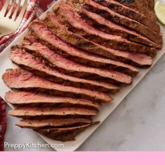 Pinterest graphic of a platter with carne asada, sliced into long pieces against the grain.