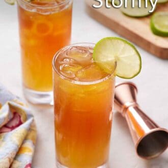 Pinterest graphic of two glasses of Dark and Stormy with a lime wheel on the edge.