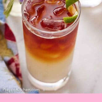 Pinterest graphic of a glass of Dark and Stormy with a lime zest garnish with some flowers on the side.