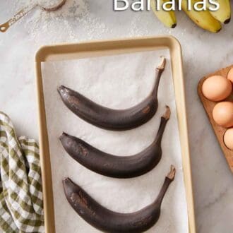 Pinterest graphic of three oven-ripened bananas on a parchment lined sheet pan on a marble surface. Eggs, bananas, and a scoop of flour off to the side.