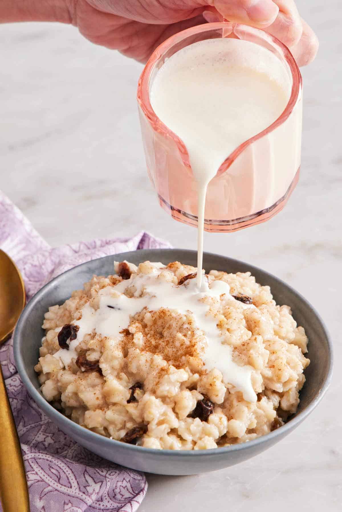 Heavy cream poured over a bowl of oatmeal.