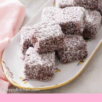 Pinterest graphic of a platter of lamingtons with flowers in the background.