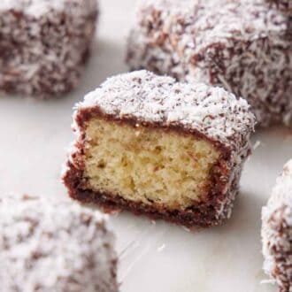 A cut lamington showing the interior with more lamingtons surrounding it.