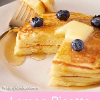 Pinterest graphic of a plate with two lemon ricotta pancakes with butter, maple syrup, and fresh blueberries on top. A bite cut out and on a fork on the side.