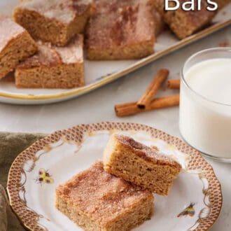 Pinterest graphic of a plate with two pieces of snickerdoodle bars. A glass of milk and platter of more snickerdoodle bars in the back.