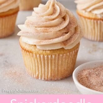 Pinterest graphic of a snickerdoodle cupcake with a bowl of cinnamon sugar beside it. More cupcakes in the background.