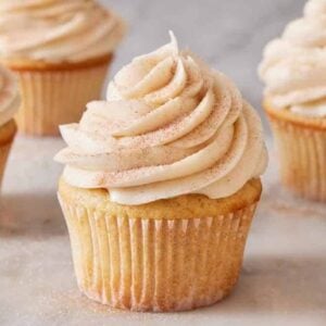 Multiple snickerdoodle cupcakes on a marble surface.