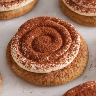 Multiple tiramisu cookies in a single layer on a marble surface.