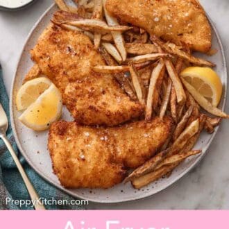 Pinterest graphic of a platter of air fryer fish and chips with three lemon wedges topped with flaky salt.