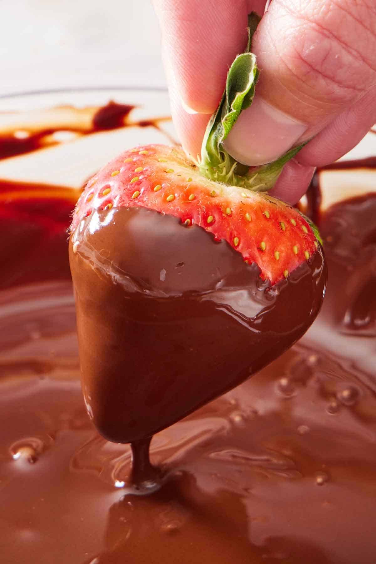 A strawberry dipped into melted chocolate.