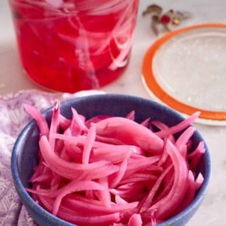 Pinterest graphic of a bowl of pickled onions with a weck jar with the lid off in the background with more.