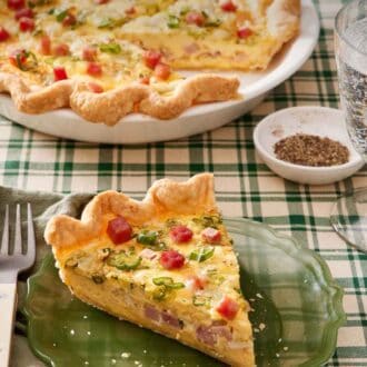 Pinterest graphic of a slice of quiche on a plate with the rest of the quiche in the background along with a bowl of pepper.