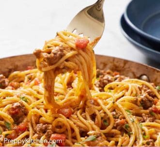 Pinterest graphic of a fork lifting up taco spaghetti from a skillet.