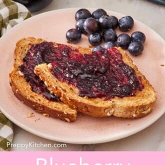 Pin image showing pieces of toasted bread with jam smeared. Also on the plate are a few whole blueberries.