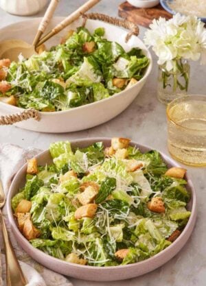 A plate of Caesar Salad with the serving bowl in the background.