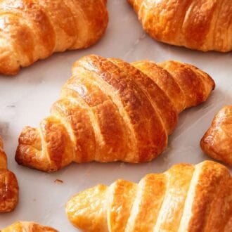 Close up of croissants on a marble surface.