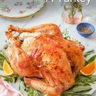 Pinterest graphic showing a roast turkey on a bed of fresh herbs and orange slices.