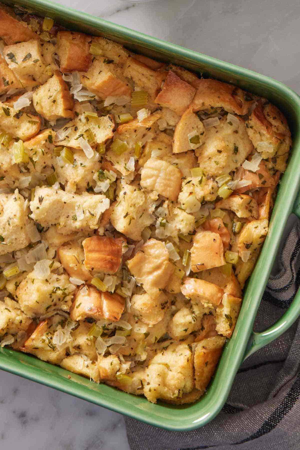 Overhead shot of homemade stuffing in a green casserole dish.