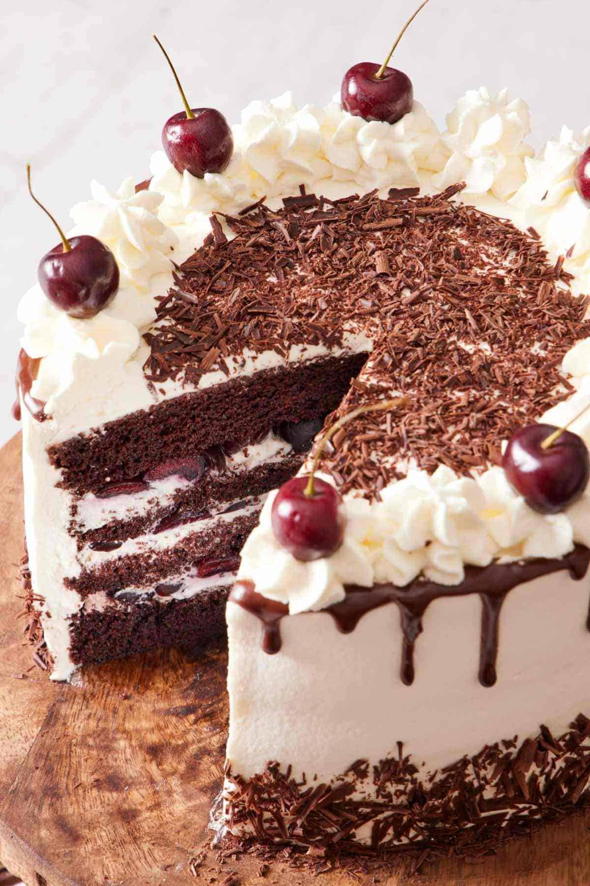 Close-up of a black forest with a slice cut out to showcase the layers.