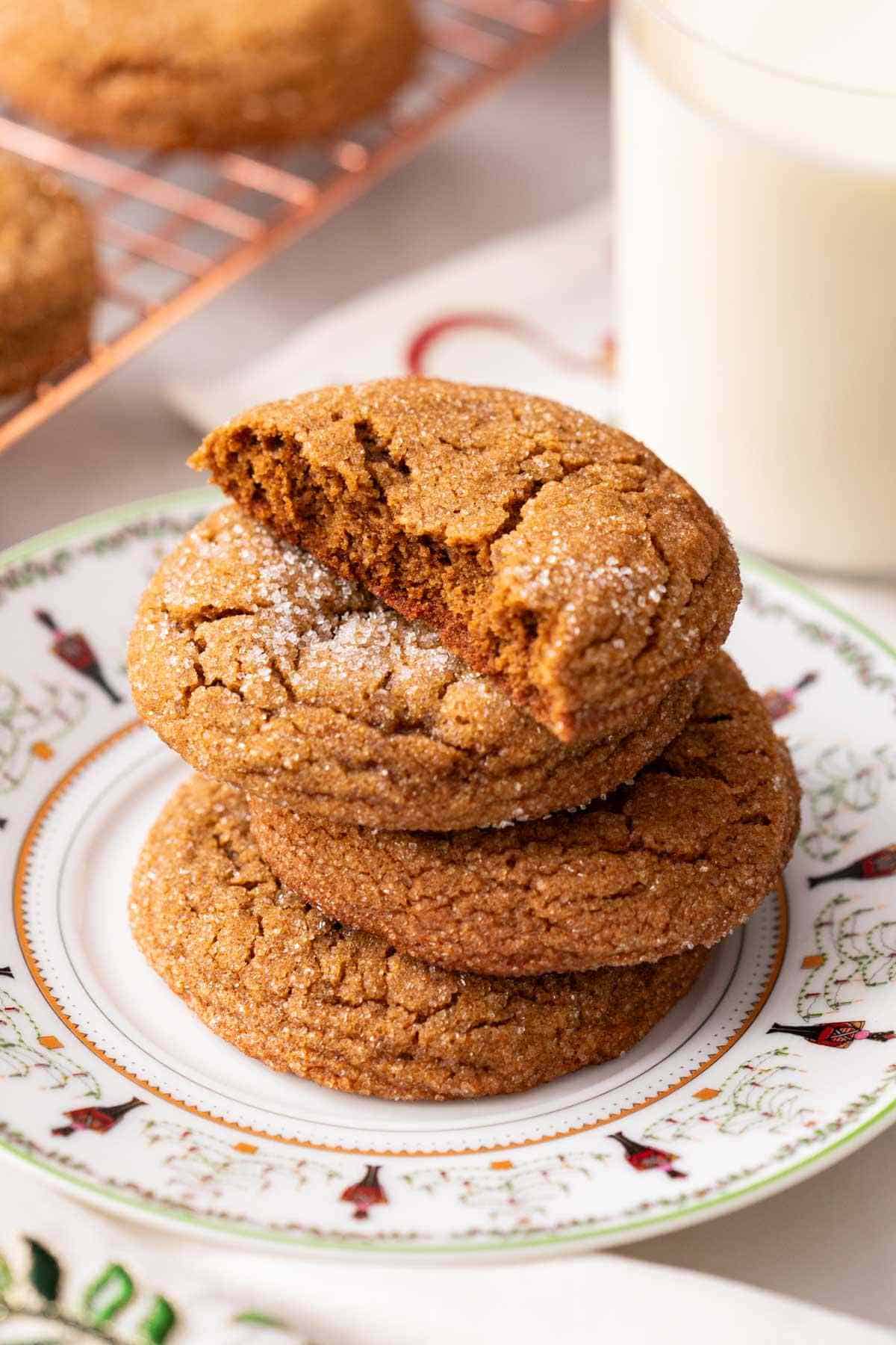 A stack of Christmas cookies on a Christmas-themed plate.