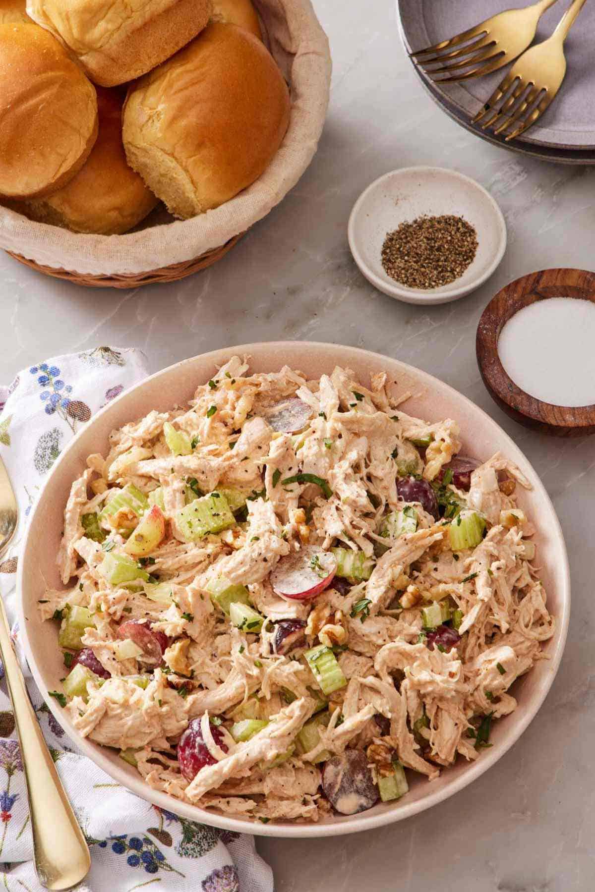 Overhead shot of Instant Pot shredded chicken salad next to rolls and salt and pepper.